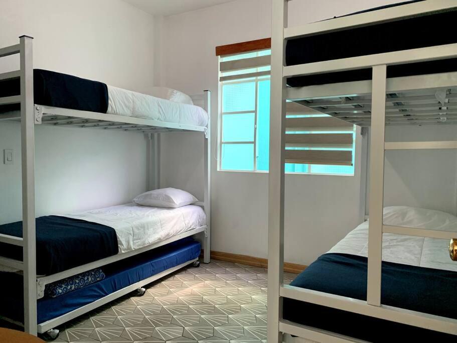 a room with two bunk beds and a window at 2D TU CASA EN CENTRO CDMX BONITO in Mexico City