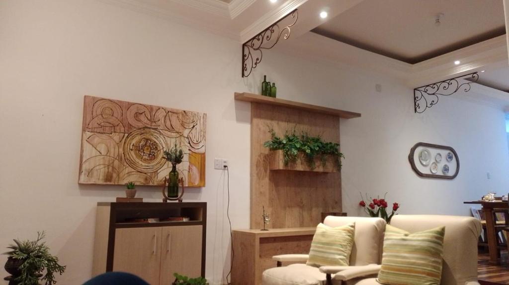 a living room with two chairs and a table at Recanto Alto da Glória in Diamantina