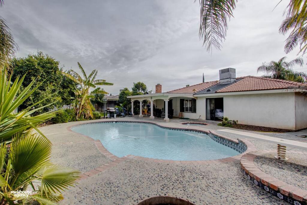 a swimming pool in front of a house at Cozy Hygge Home Centrally Located 2 King Beds in Bakersfield