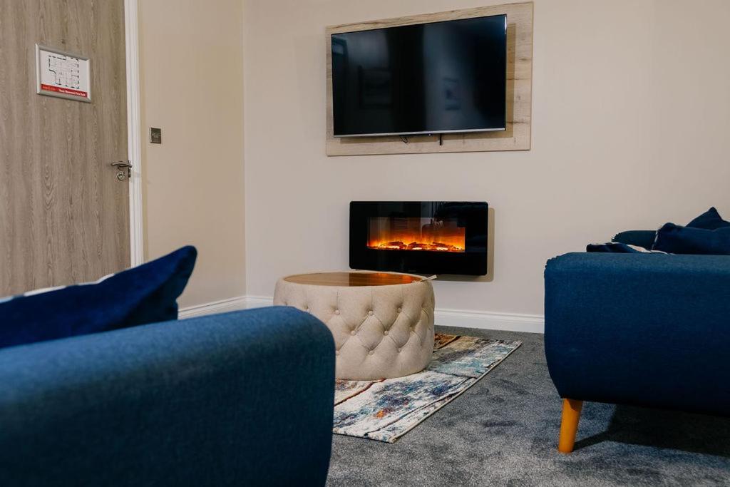 a living room with two chairs and a fireplace at The Portland in Ashington