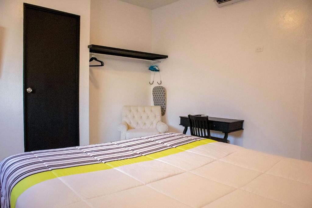 1 dormitorio con cama, silla y escritorio en Donjuan By Melida Hotel, en Cabo San Lucas
