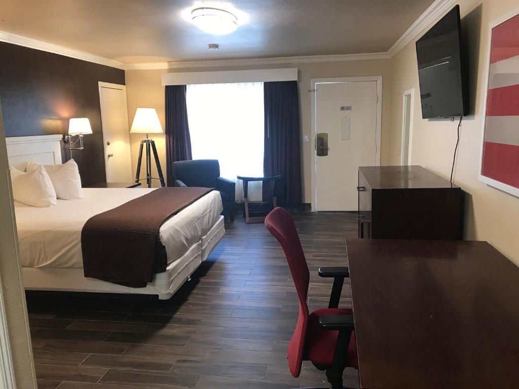 Habitación de hotel con cama, mesa y sillas en Abby's Anaheimer Inn - Across Disneyland Park, en Anaheim