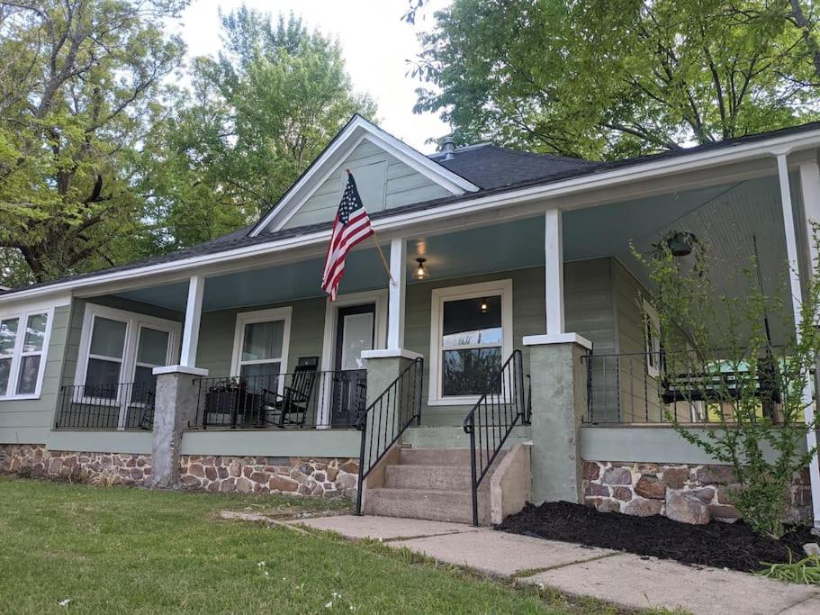 a house with an american flag in front of it at The Ouachita Depot in Mena