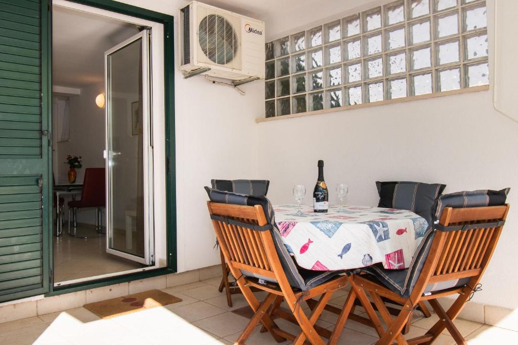 a dining room with a table with a bottle of wine at Apartment Pave by Zamalin beach in Tribunj