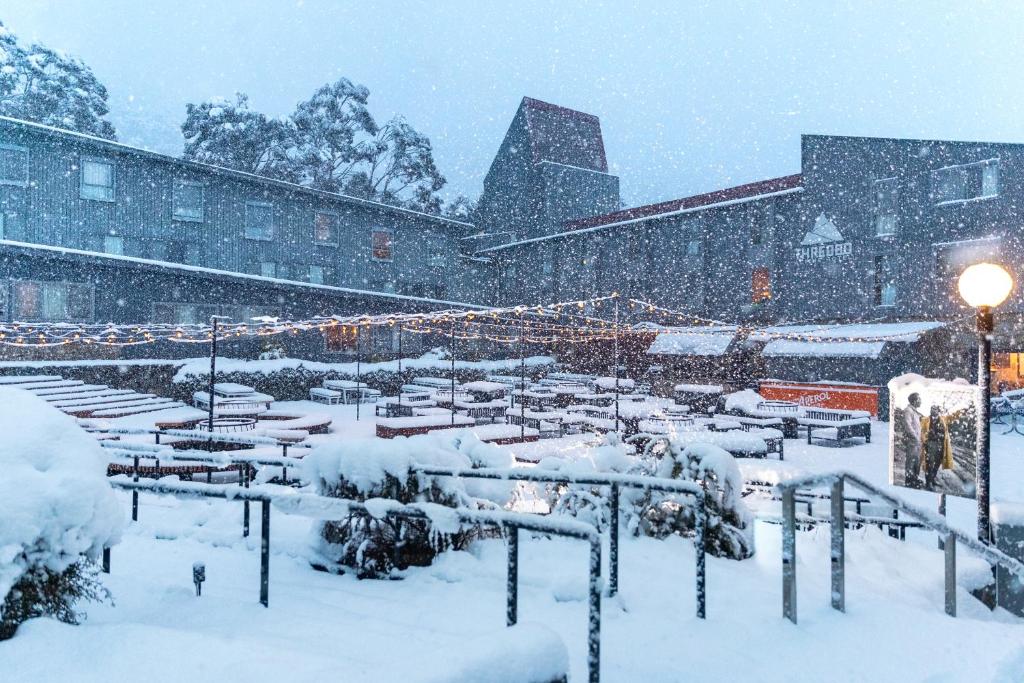 a city street with a snow covered building at Thredbo Alpine Hotel in Thredbo