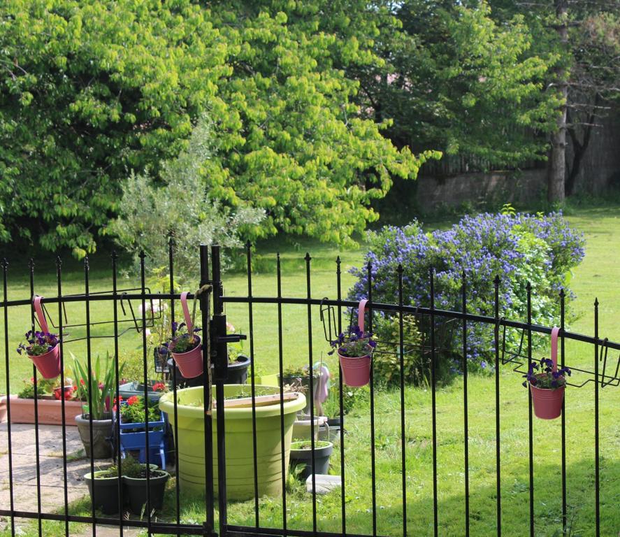 uma cerca com vasos de plantas num jardim em Chez Martine et Bernard em Saint-Vincent-Sterlanges