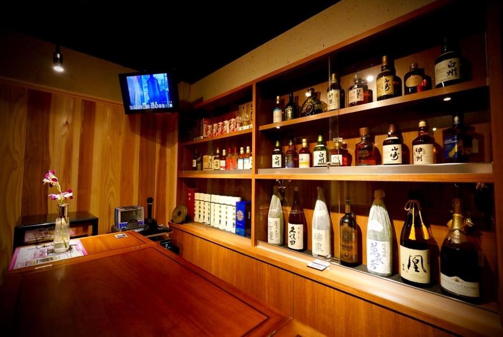 un bar con un montón de botellas de alcohol en Kougetsu Sanso -- Moon Villa in Tokyo en Hachioji