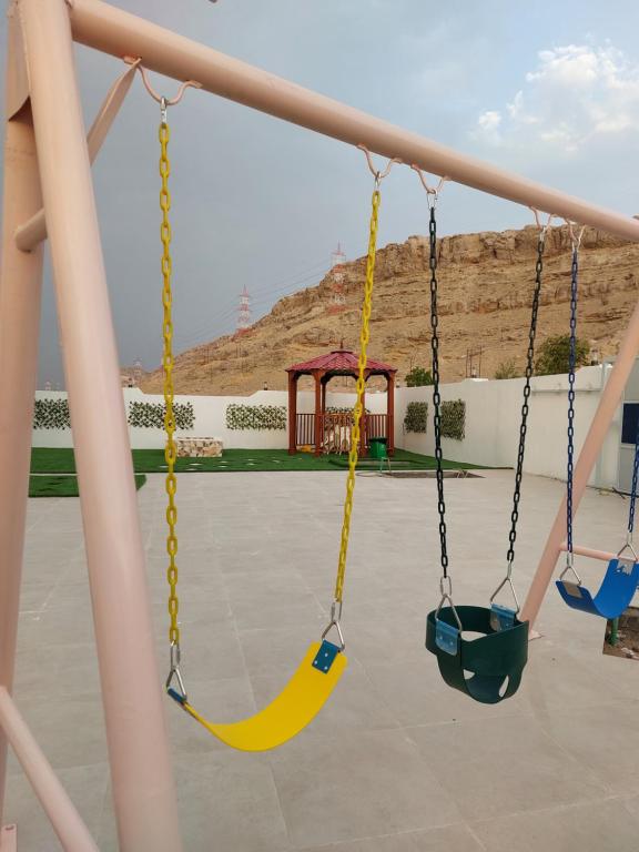 a swing set at a playground at فيلا تل الورد in Ibri