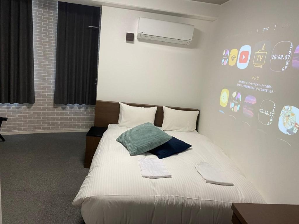 um quarto com uma cama branca e uma almofada verde em TAPSTAY HOTEL - Vacation STAY 35238v em Saga