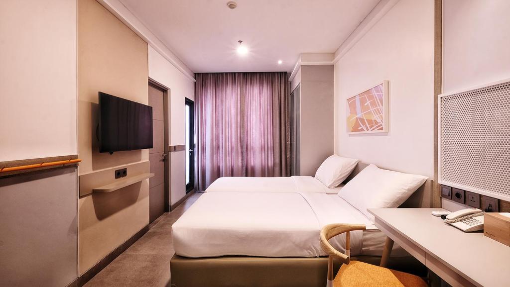 Habitación de hotel con cama y escritorio en Joylive BSD City en Tangerang
