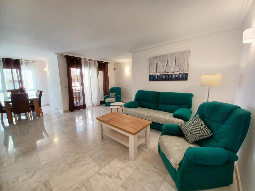 a living room with green couches and a table at APARTAMENTO MORAIRA - 3 Habitaciones in Moraira