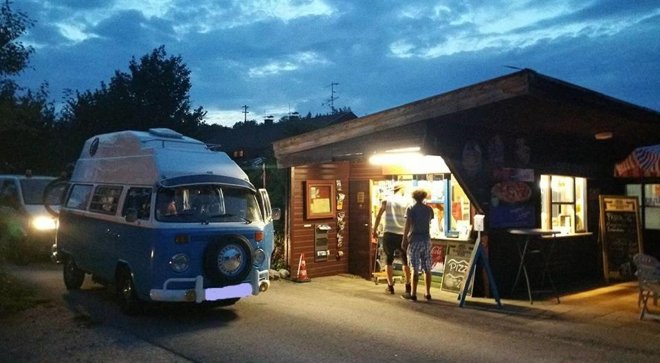 een oud busje geparkeerd voor een winkel bij Campingplatz Mariengrund in Bernau am Chiemsee