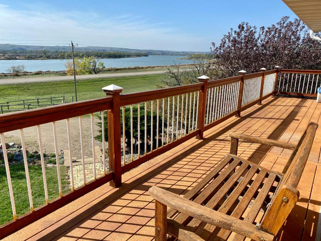 una terraza de madera con un banco y vistas al agua en Farm Island Missouri River Views, en Pierre