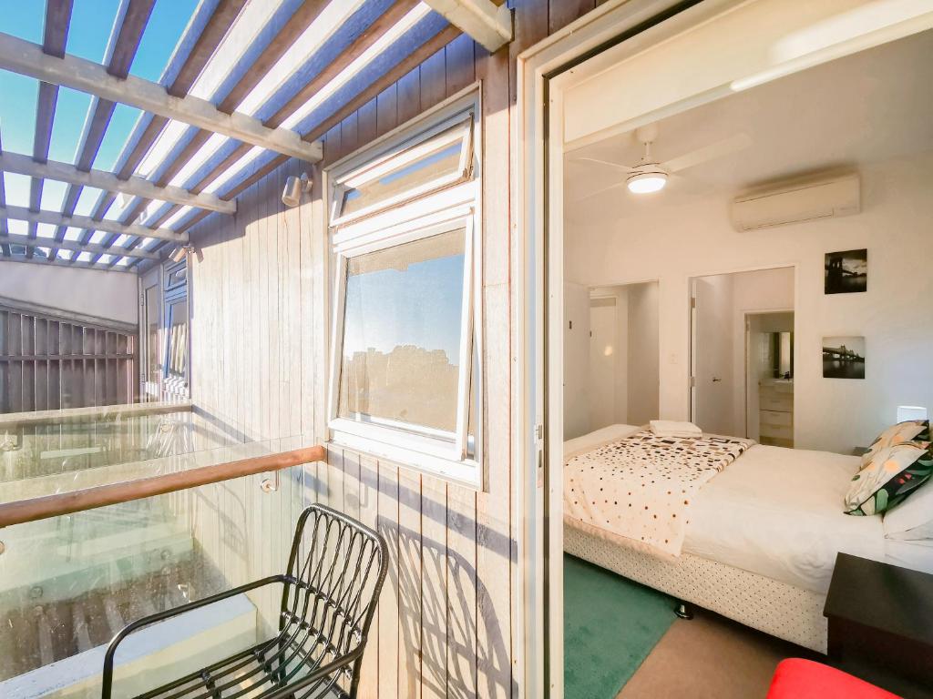a bedroom with a balcony with a bed and a window at Glebe House Homestay in Sydney