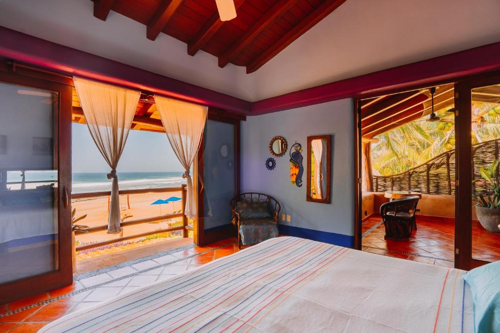 a bedroom with a bed and a view of the ocean at Tres Mujeres Hotel in Troncones