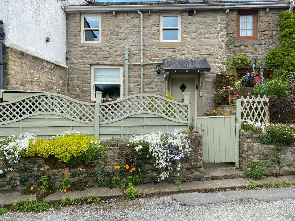 ein Steinhaus mit einer Bank davor in der Unterkunft 4 Castle View in Barnoldswick