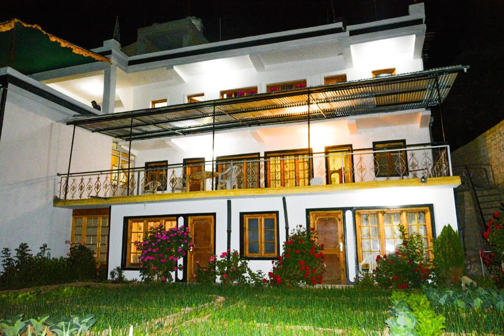 a white house with a balcony on top of it at Zeejeed palace in Leh