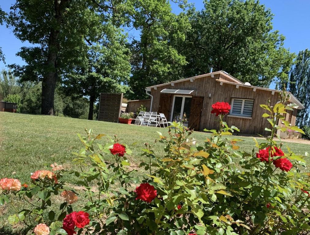 a tiny house in a yard with flowers at La Grenouillère in Caussade