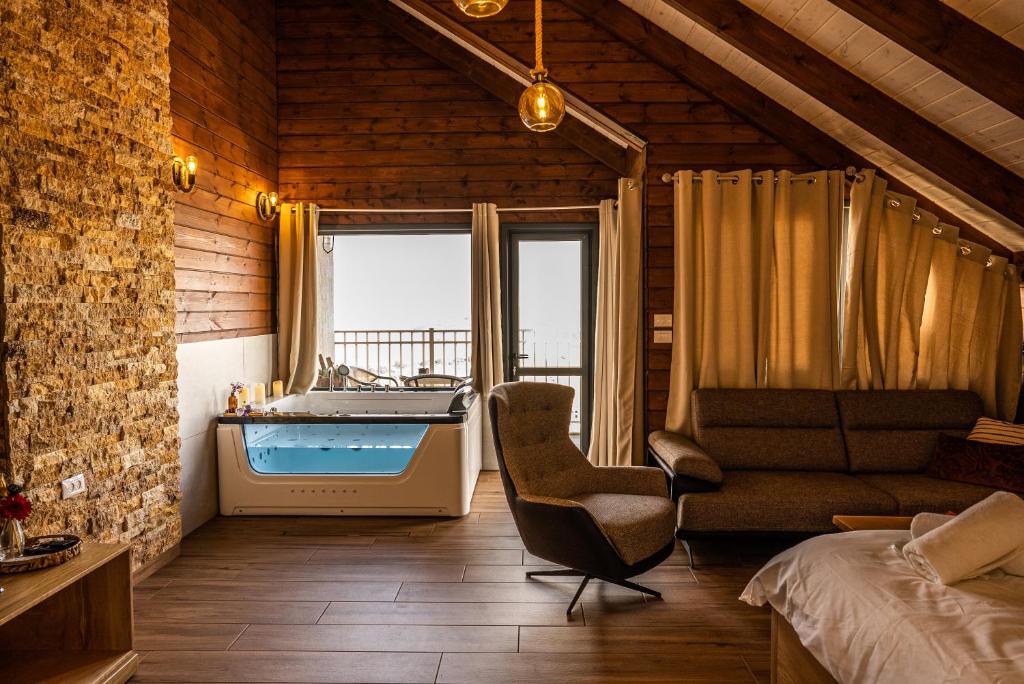 マジダル・シャムスにあるארואד סוויטס Arwad suitesのバスタブ、椅子、ベッド1台が備わる客室です。