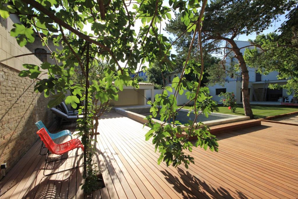 una silla roja sentada en una terraza de madera en La Maison de l'Olivier en Aviñón