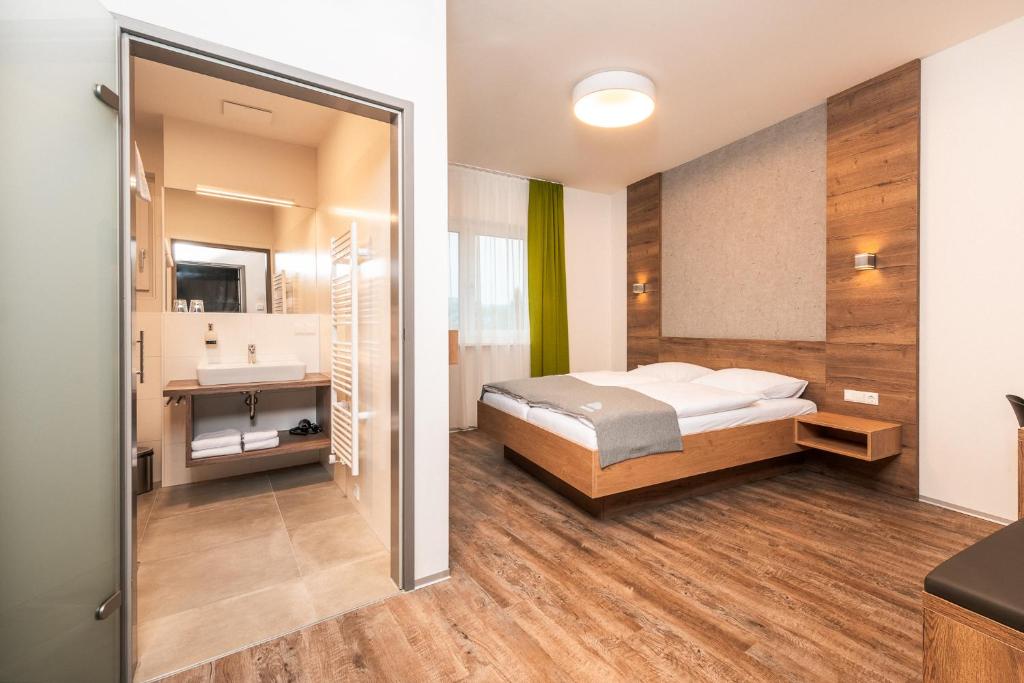 a bedroom with a bed and a sink at Das schlaf&GUT - Self Check-In in Leibnitz