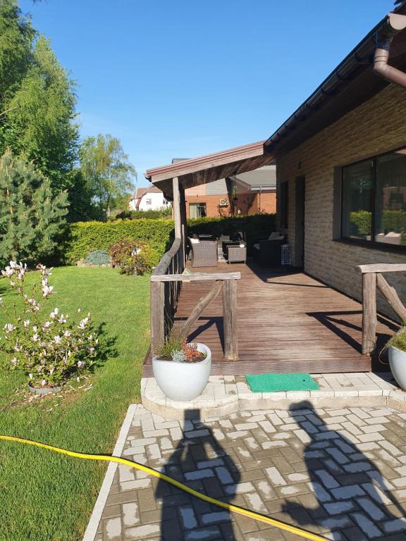 a backyard with a wooden deck with a picnic table at Privatus namas in Šilutė