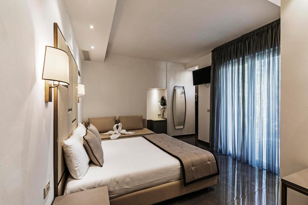 Habitación de hotel con cama y ventana grande en Hotel Des Bains, en Cattolica
