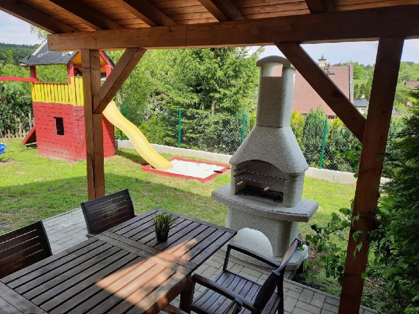 patio con chimenea de piedra y parque infantil en Chalupa Denis & Marek, en Kovářská