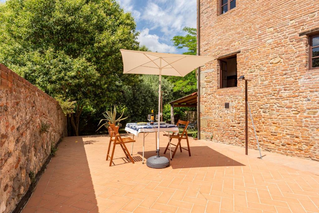 un patio con mesa y sombrilla en La Casina di Elisa, en Montecarlo