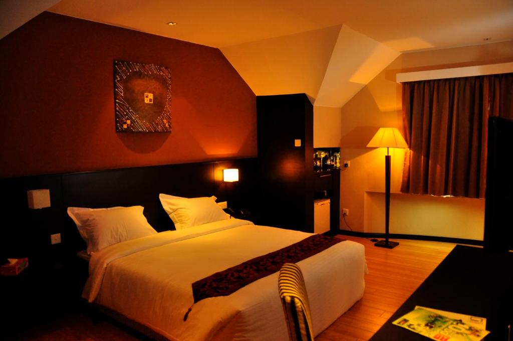 1 dormitorio con 1 cama blanca grande en una habitación en Tat Place Hotel, en Kuala Belait