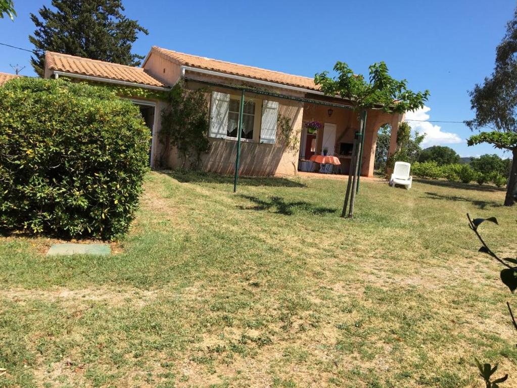 une petite maison avec une pelouse devant elle dans l'établissement Gite au milieu des vignes g285, à Vidauban