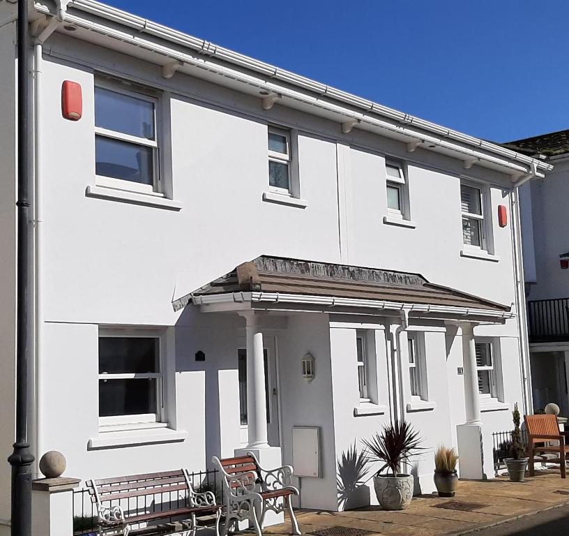 a white house with benches in front of it at Fifteen in Seaton