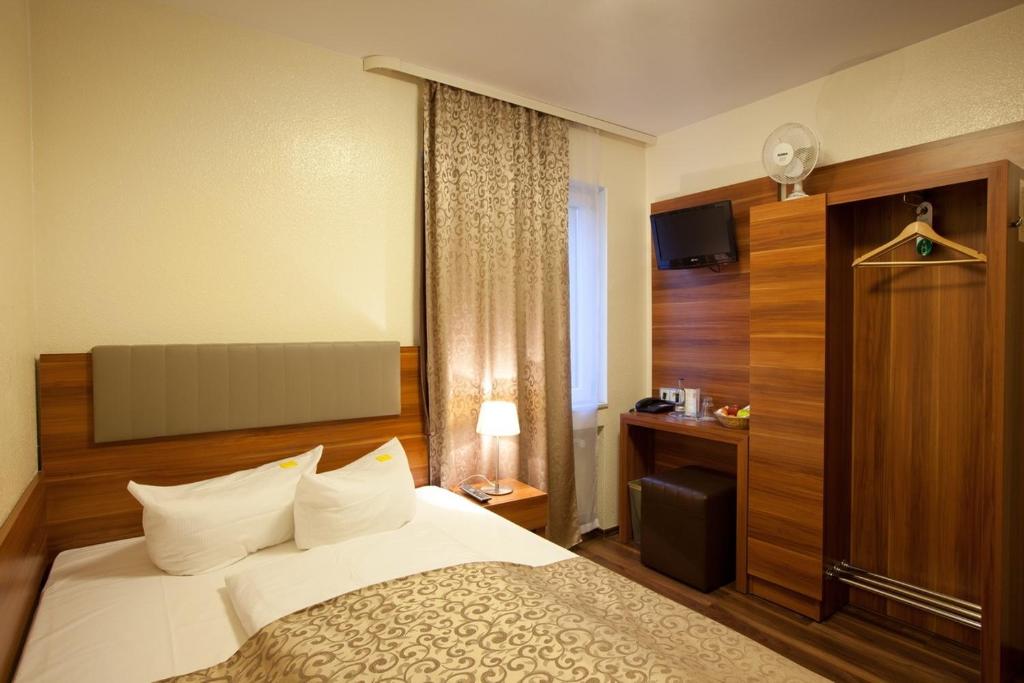美因河畔法兰克福Hotel Frankfurt Messe的一间有床和窗户的酒店房间
