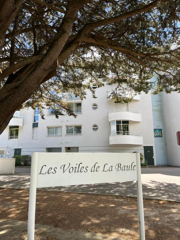 un panneau devant un bâtiment blanc dans l'établissement Studio Les Voiles de la Baule, à La Baule