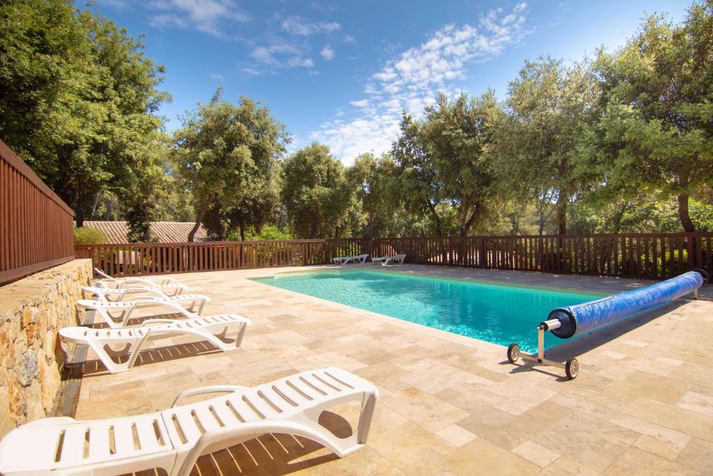 a pool with lounge chairs and a water slide at Le Mas des Bois in Le Muy