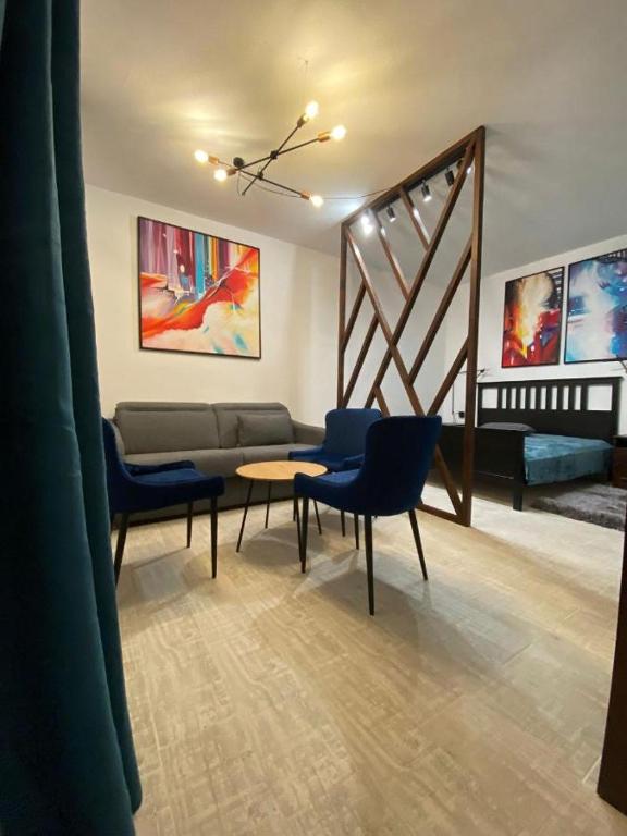 ein Wohnzimmer mit einem Sofa, Stühlen und einem Tisch in der Unterkunft Cabana B2 langa strandul Banffy in Topliţa