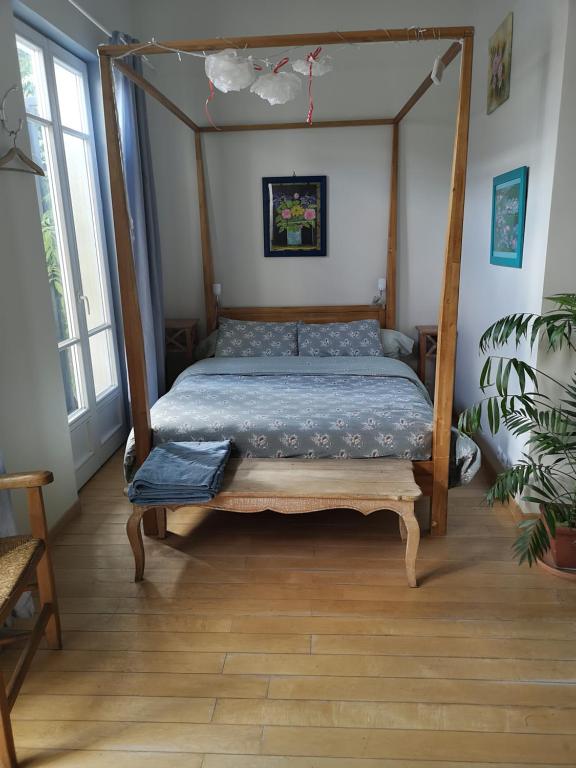 - une chambre avec un lit doté d'un cadre en bois dans l'établissement Chambre en ville dans un esprit campagne, à Troyes