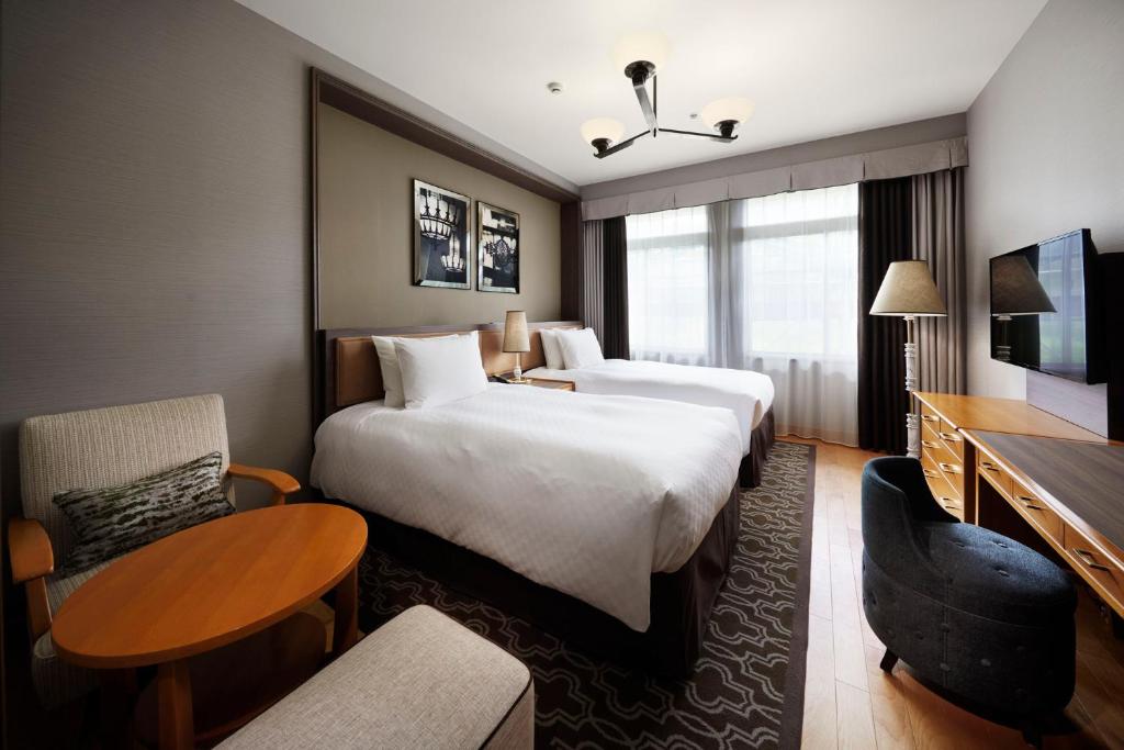 Postel nebo postele na pokoji v ubytování Kawana Hotel
