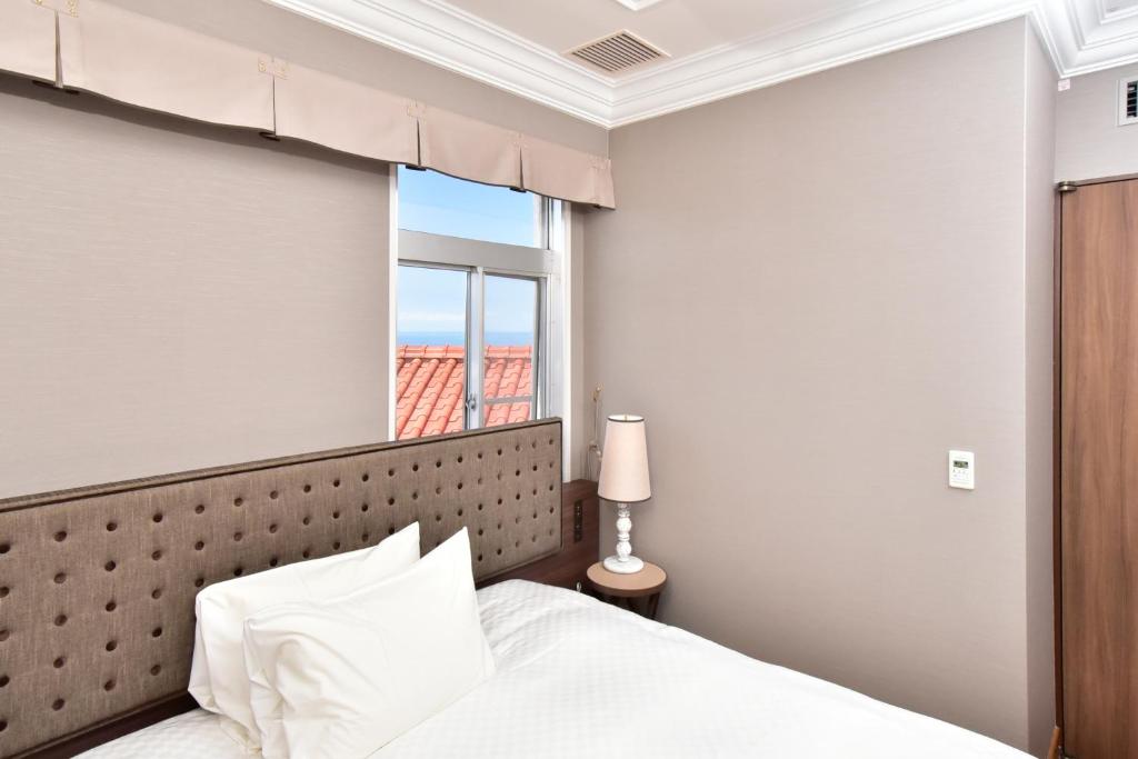 Postel nebo postele na pokoji v ubytování Kawana Hotel