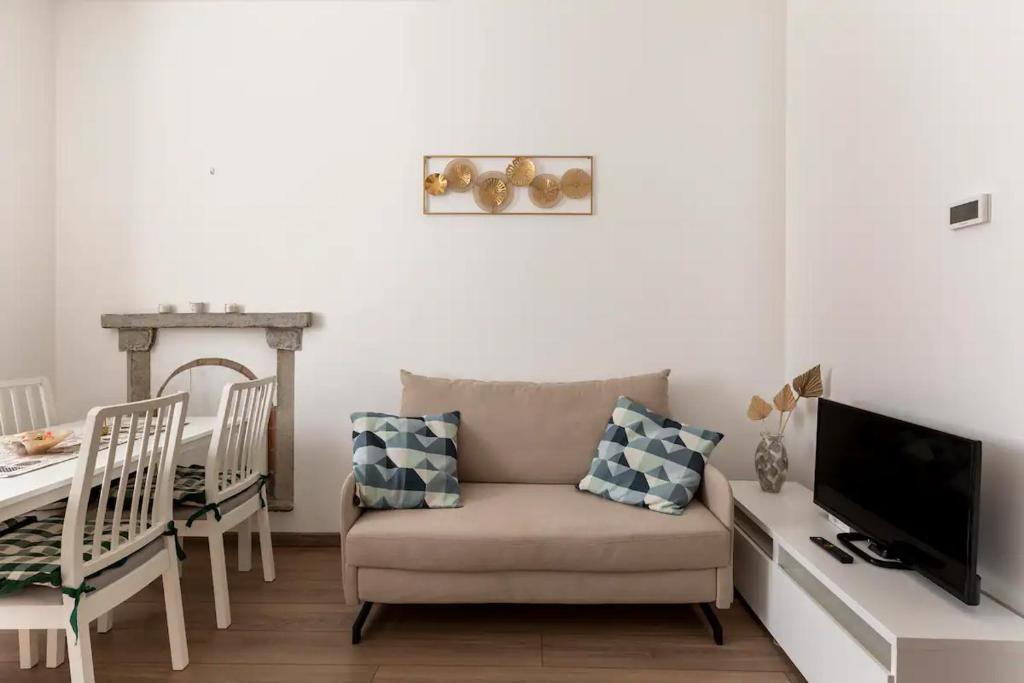 un soggiorno con sedia e TV di Anita's Apartment a Como