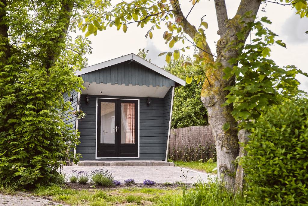 uma pequena casa cinzenta com uma porta preta em Chalet Terra Incognito em Westerland