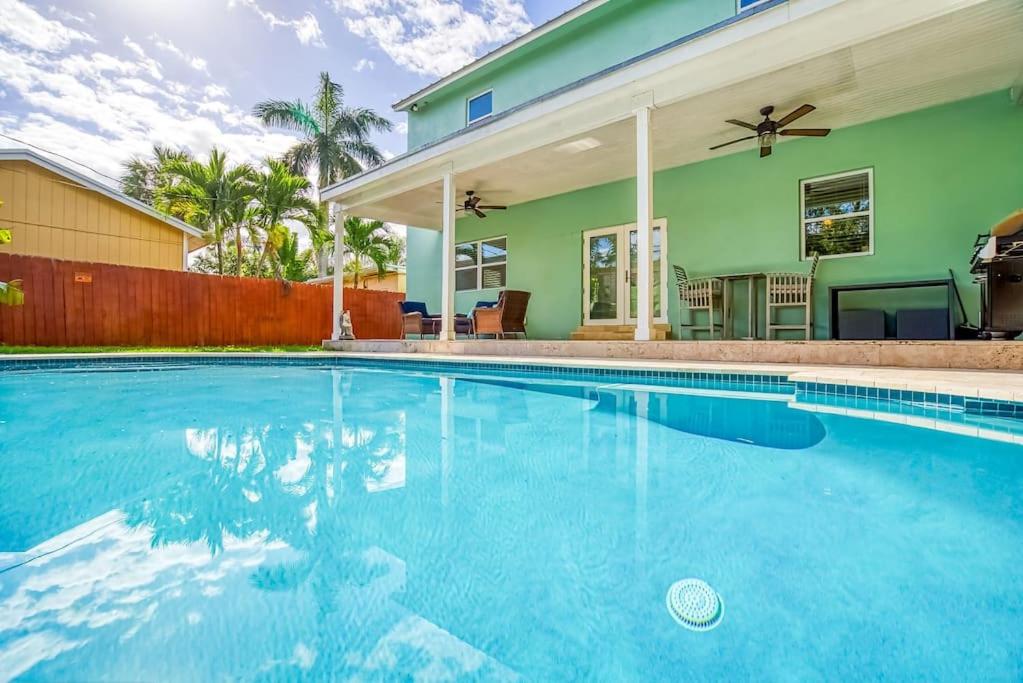 a swimming pool in front of a house at Las Olas Villa with HEATED Salt Water Pool in Fort Lauderdale