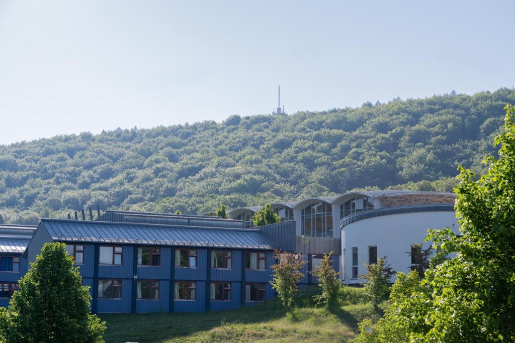 a building with a mountain in the background at Sportcampus Saar in Saarbrücken