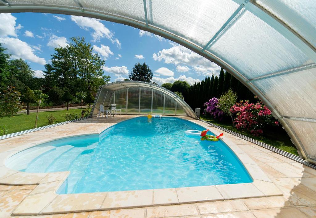 a swimming pool under a greenhouse in a backyard at JD Apartamenty - Klimatyzacja, basen, parking i wifi w cenie in Mysłakowice