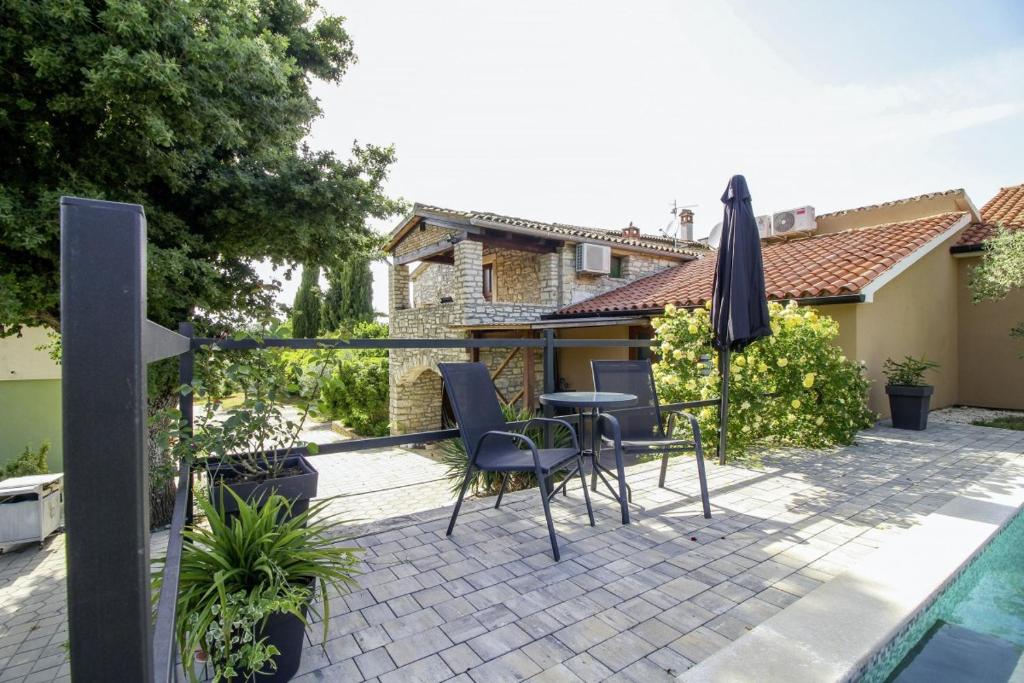 a patio with a table and chairs and an umbrella at Mani in Pilkovići - Istrien in Kanfanar