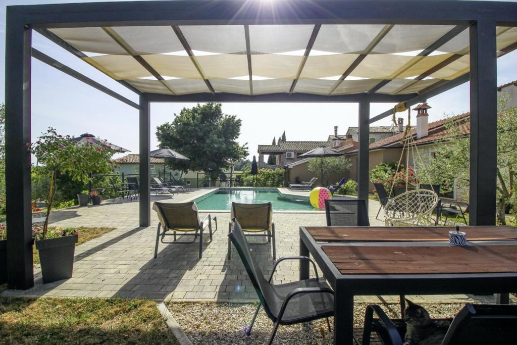 a patio with a table and chairs and a pool at Mani in Pilkovići - Istrien in Kanfanar