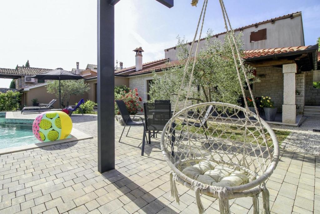 a swinging chair in a yard with a pool at Mani in Pilkovići - Istrien in Kanfanar