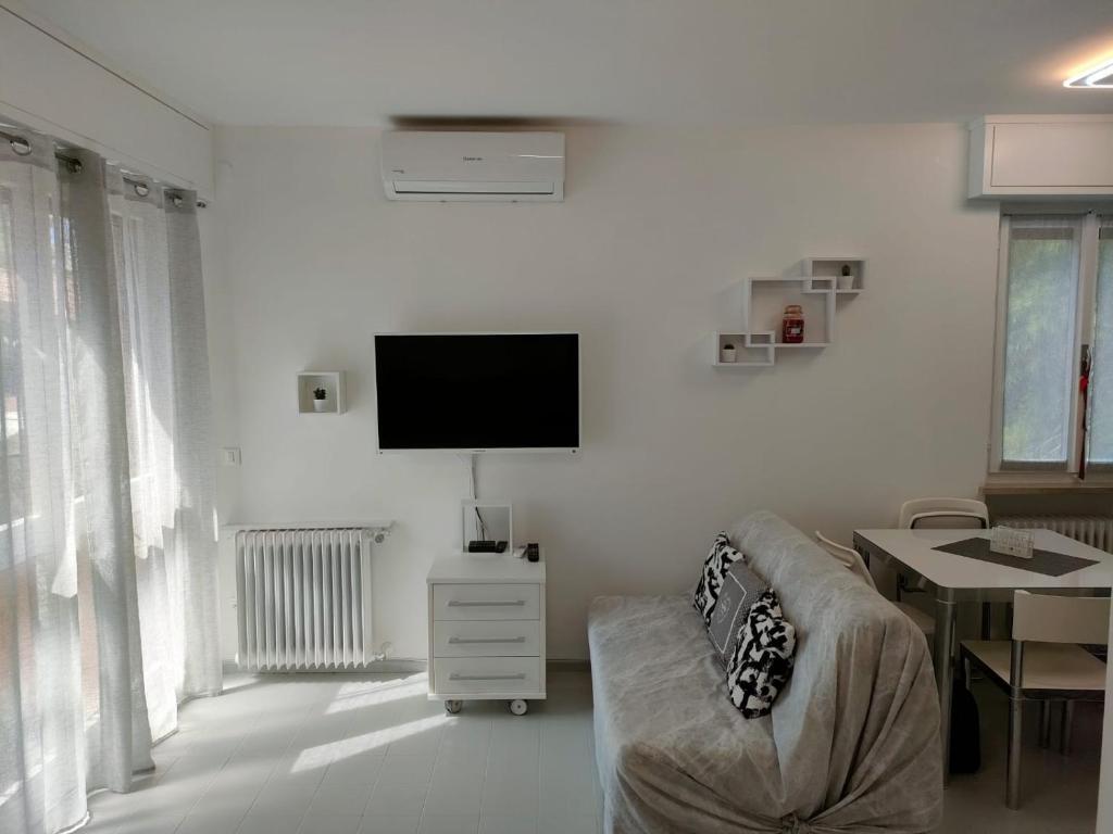 a living room with a couch and a flat screen tv at Appartamento Mirabell, FRONTE SPIAGGIA, VISTA MARE CON PARCHEGGIO in Grado