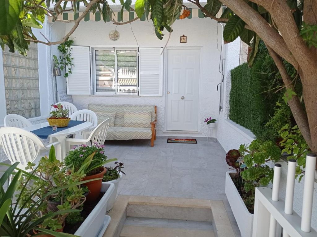 un patio con plantas, mesa y sillas en Bungalow los Majuelos, en Gran Alacant