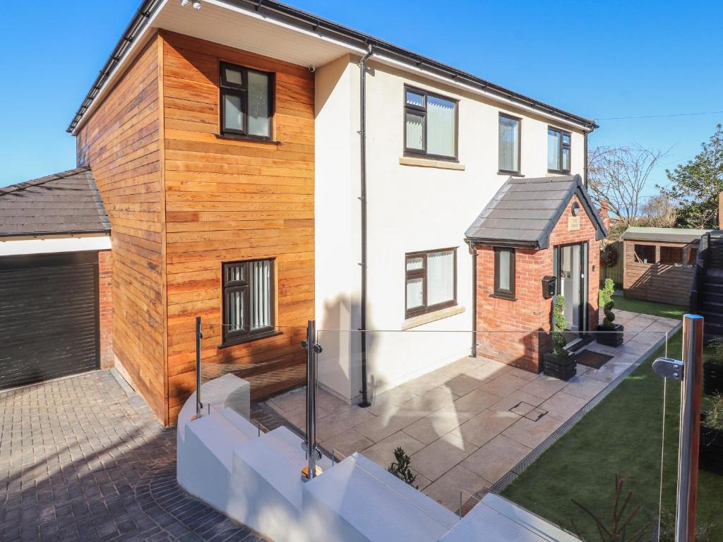 a house with a wooden facade and a courtyard at The Mount in Prestatyn